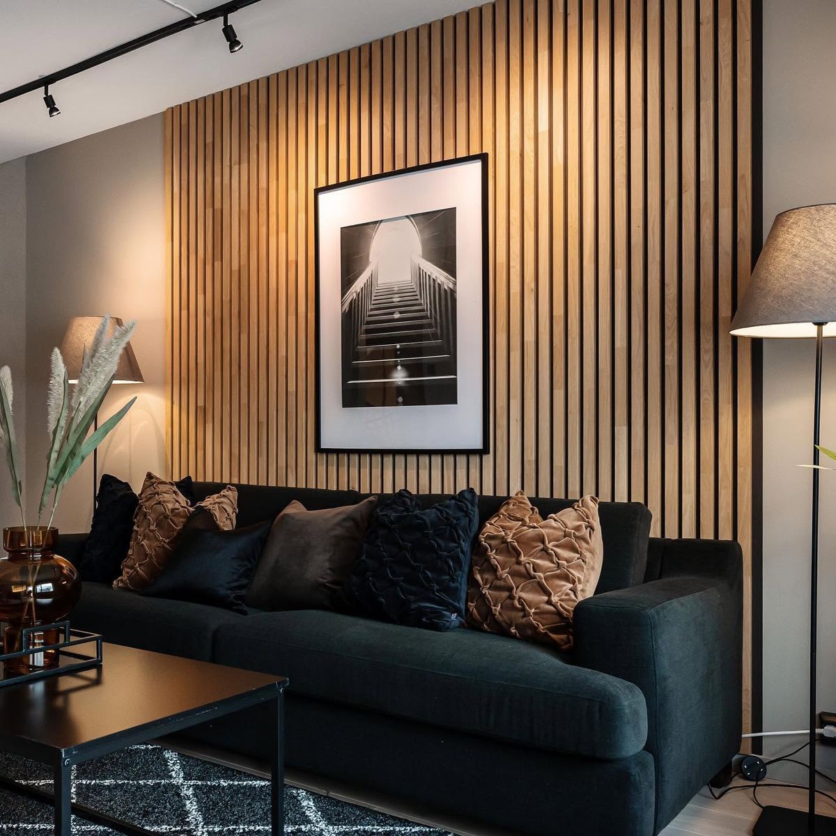 Lun stue med spilevegg og mørk sofa