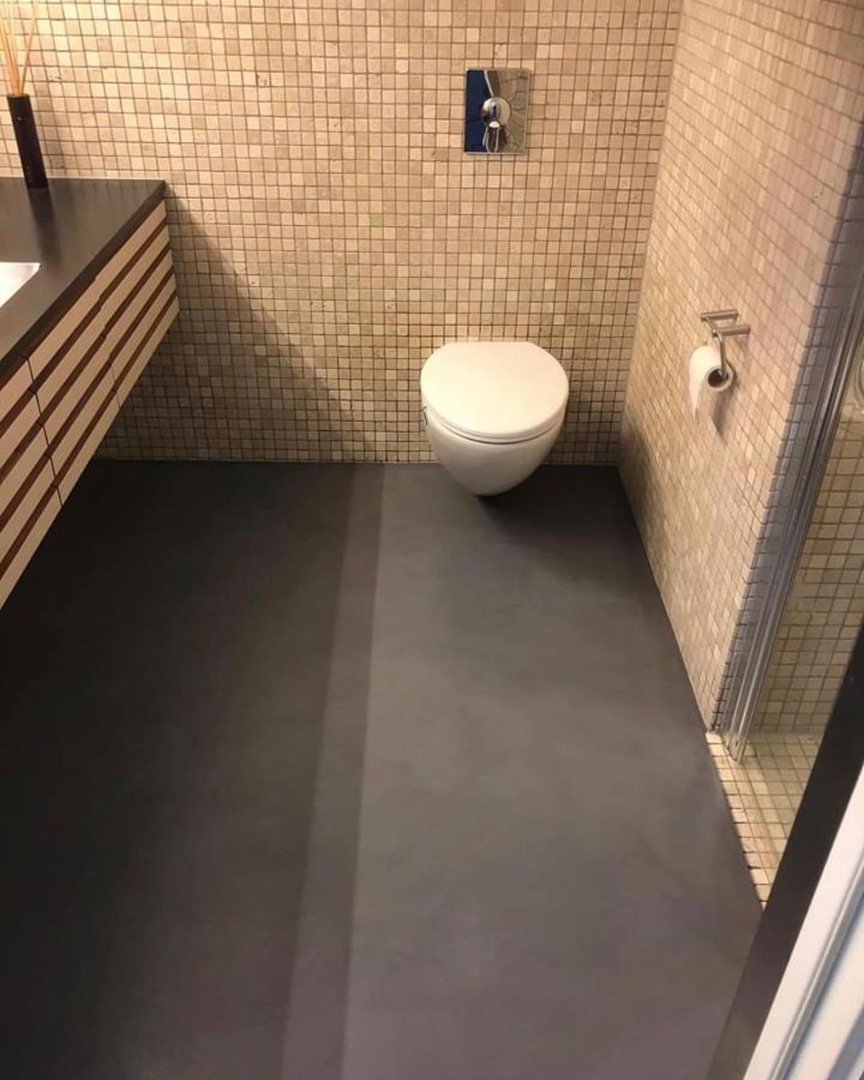 Toalettrom med mosaikk og mørkt gulv